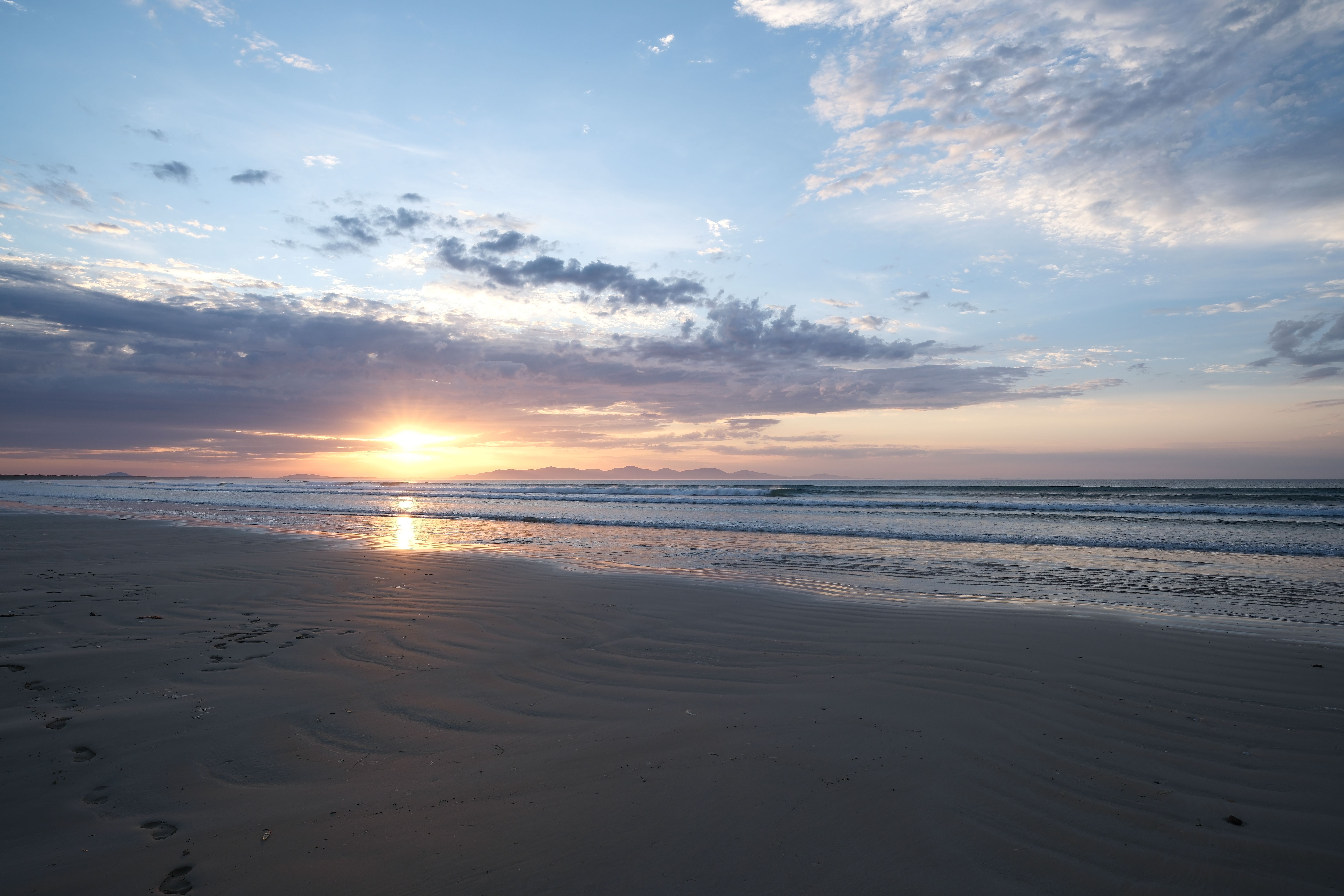 Serene Beach Sunrise with Gentle Waves · Free Stock Photo