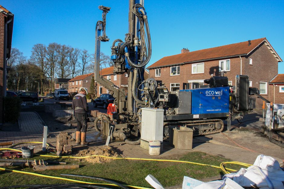 Photo by Freek Wolsink on Pexels Construction site with worker and drilling machine operating near residential area on a sunny day.