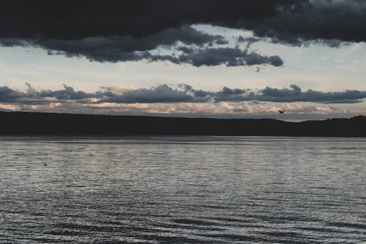 黄昏时分，多云天空充满戏剧性，映衬着宁静的湖景，营造出一种平静的氛围