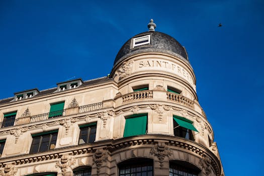 A classic European architectural building with prominent green shutters under a clear blue sky.