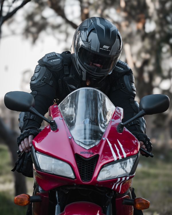 Motorcyclist in Black Gear Riding Red Sport Bike · Free Stock Photo