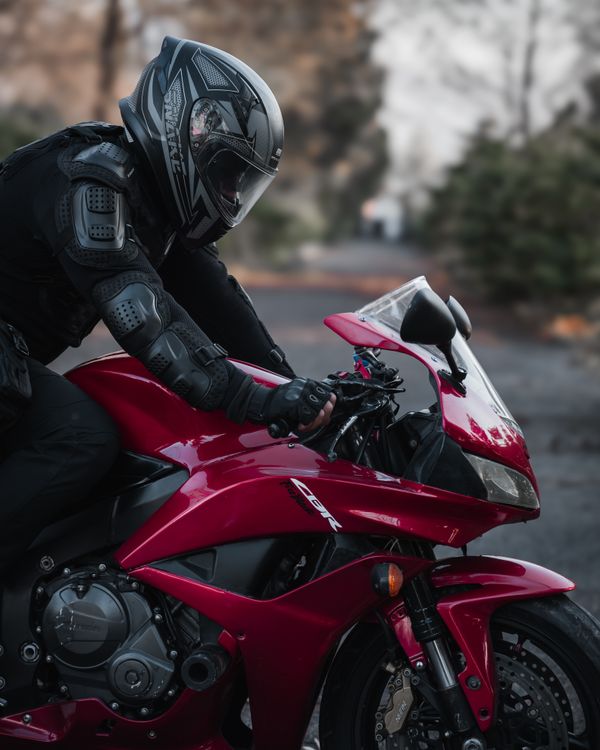 Motorcyclist in Full Gear Riding a Red Sportbike · Free Stock Photo