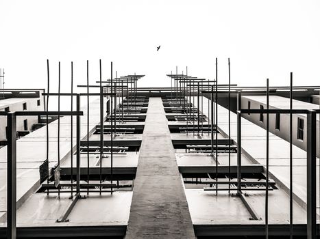 Dramatic architectural upward view with a bird flying above, showcasing modern cityscape.