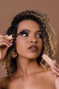Close-up of a woman applying mascara, highlighting makeup and beauty routine.
