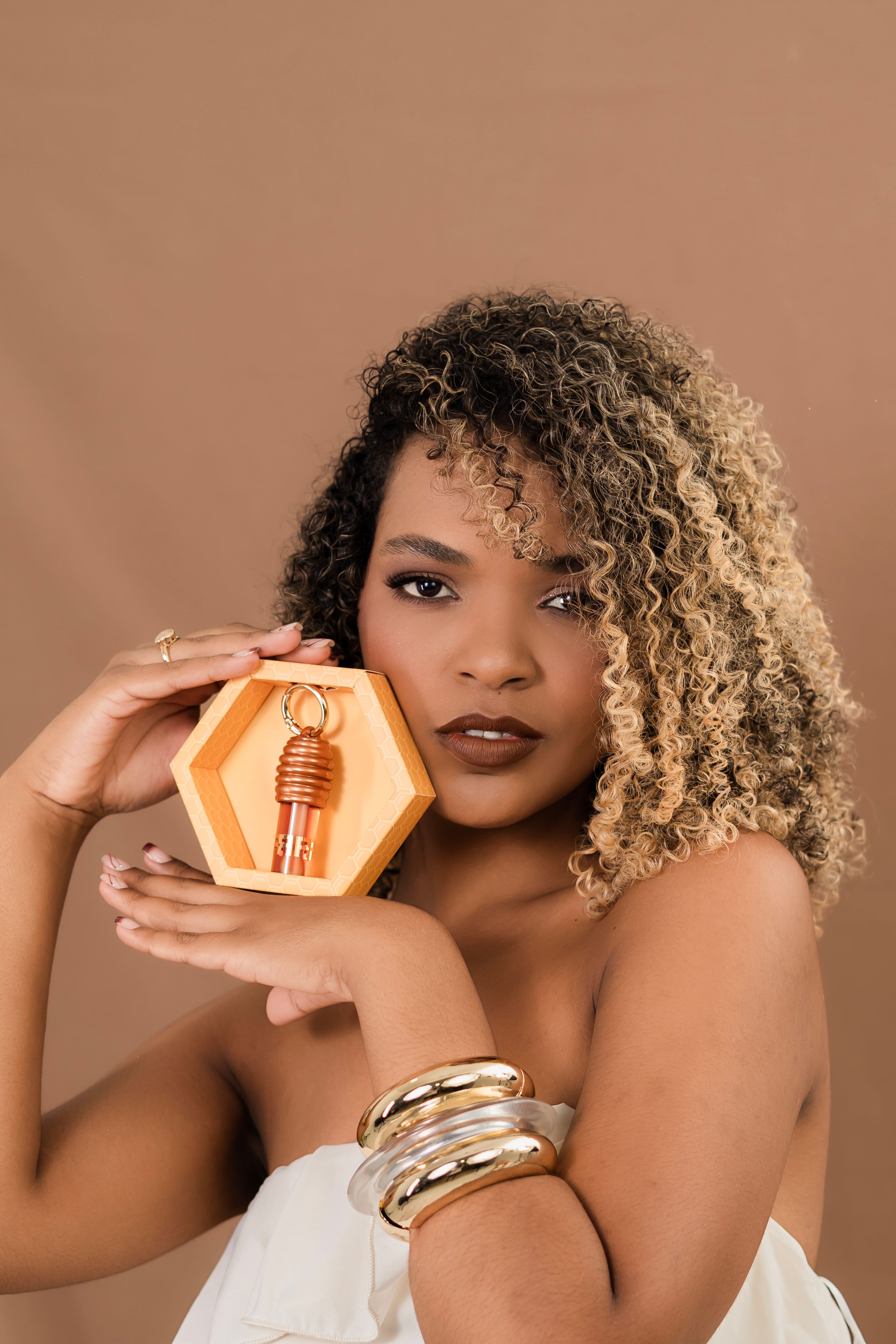 Fashion portrait of a woman displaying a honeycomb ornament, blending elegance and style.