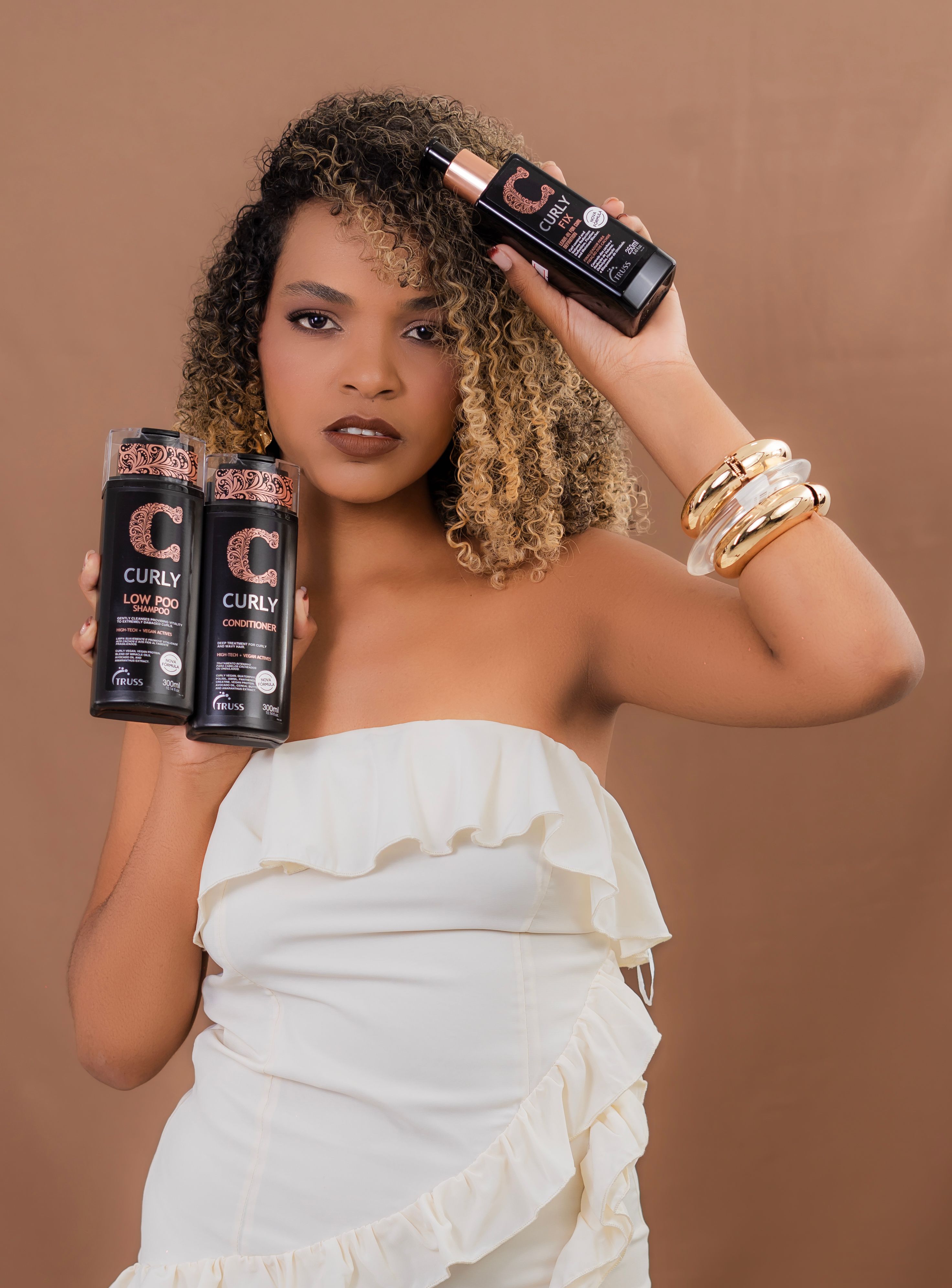 Two rich leave-in conditioning creams beside a wide-tooth comb for dry curly hair
