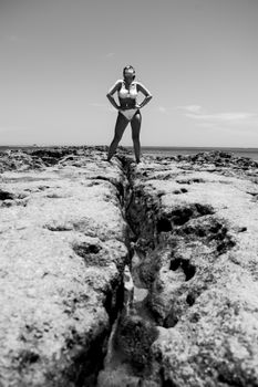 Woman on rocky beach in black and white, Porto Seguro, Brazil