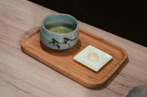 Free A close-up of a ceramic tea cup and dish on a wooden tray, offering a minimalist aesthetic. Stock Photo