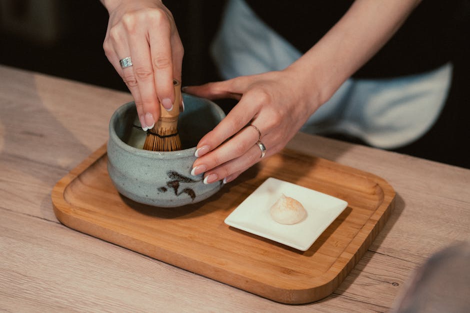 A tea master gracefully whisking matcha into a froth - authentic Japanese tea ceremony A tea master gracefully whisking matcha into a froth - authentic Japanese tea ceremony