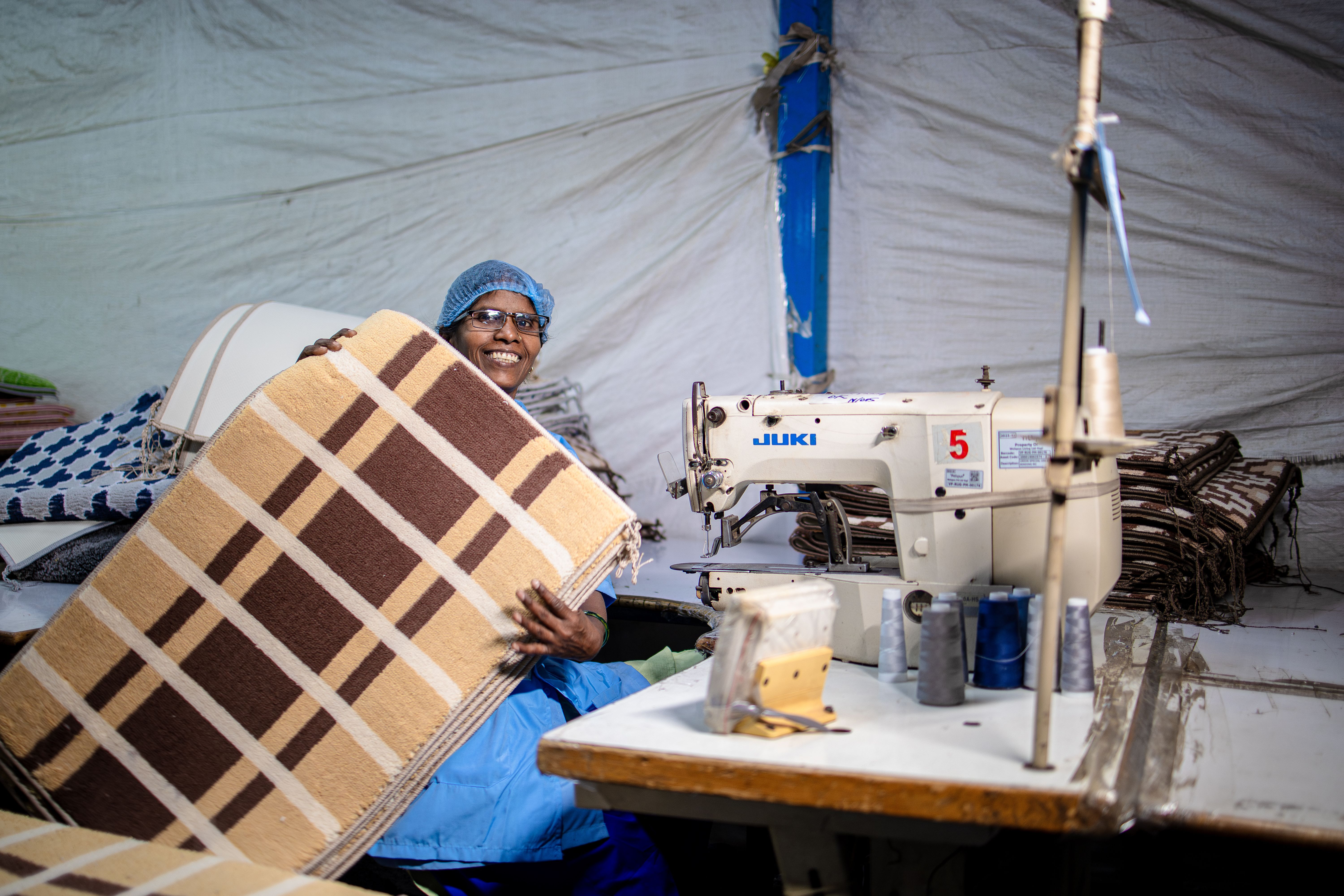 Smiling Factory Worker Holding Textile Product · Free Stock Photo