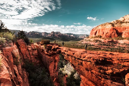 Explorers hiking on Sedona's stunning red rock formations under a vibrant sky.