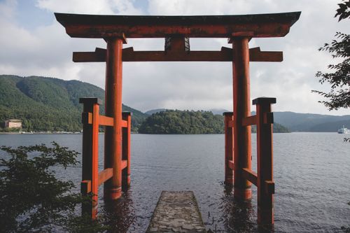 Free Scenic view of the iconic Torii gate at Lake Ashi in Hakone, Japan, surrounded by lush mountains. Stock Photo