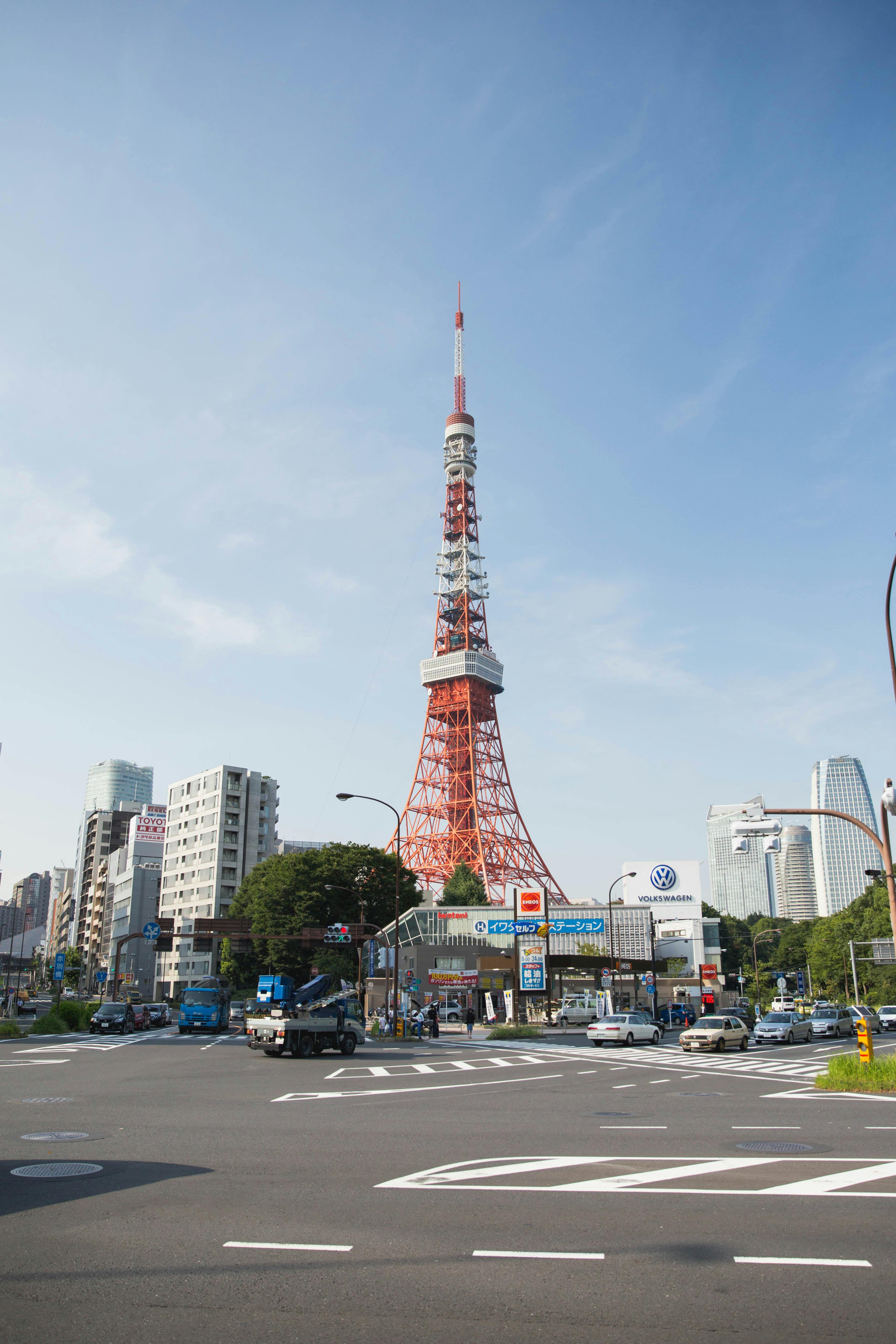 A clear and sunny view of Tokyo Tower amidst city buildings in Minato City, Tokyo.
