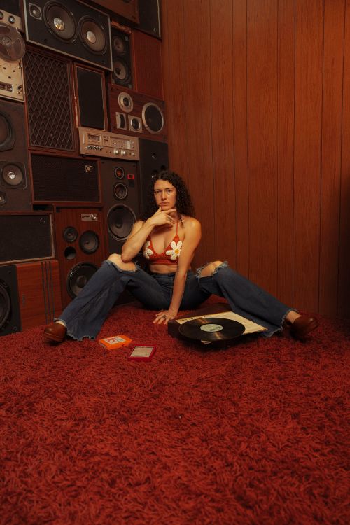 Free Person relaxing in a vintage room with vinyl records and retro speakers, creating a nostalgic music vibe. Stock Photo