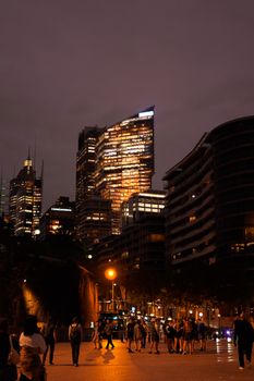 A bustling city scene at night with lit skyscrapers and people walking. Perfect for urban themes.