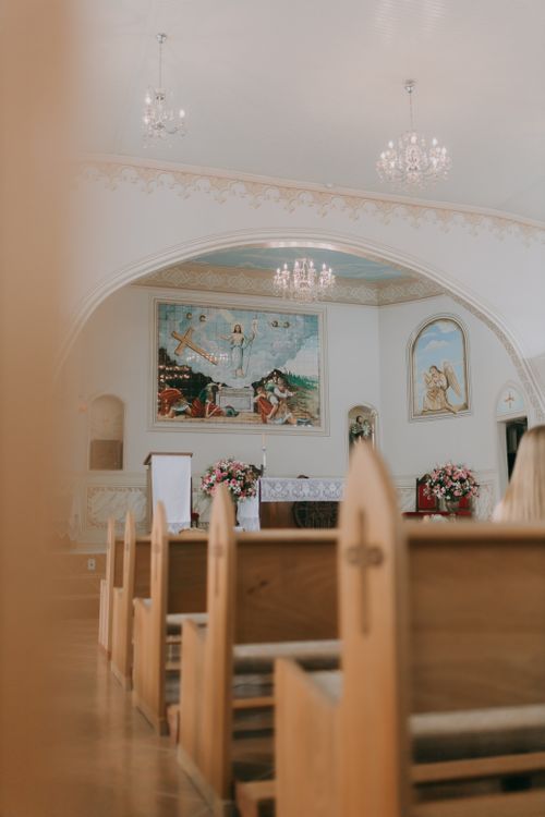 Free A serene church interior with pews, chandeliers, and religious art. Ideal for spiritual themes. Stock Photo
