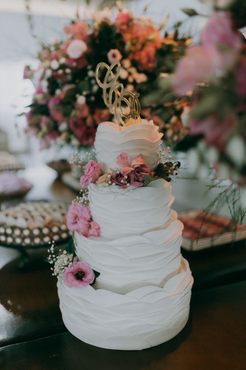 Free Stunning white wedding cake adorned with pink flowers, perfect for an elegant wedding celebration. Stock Photo
