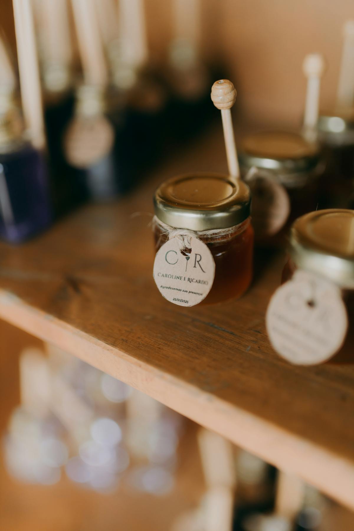 Primo piano di barattoli di miele artigianale con cucchiaini su scaffale rustico