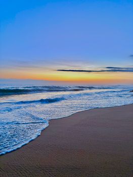 Vibrant beach waves under colorful sunset in Puerto Escondido, Mexico.