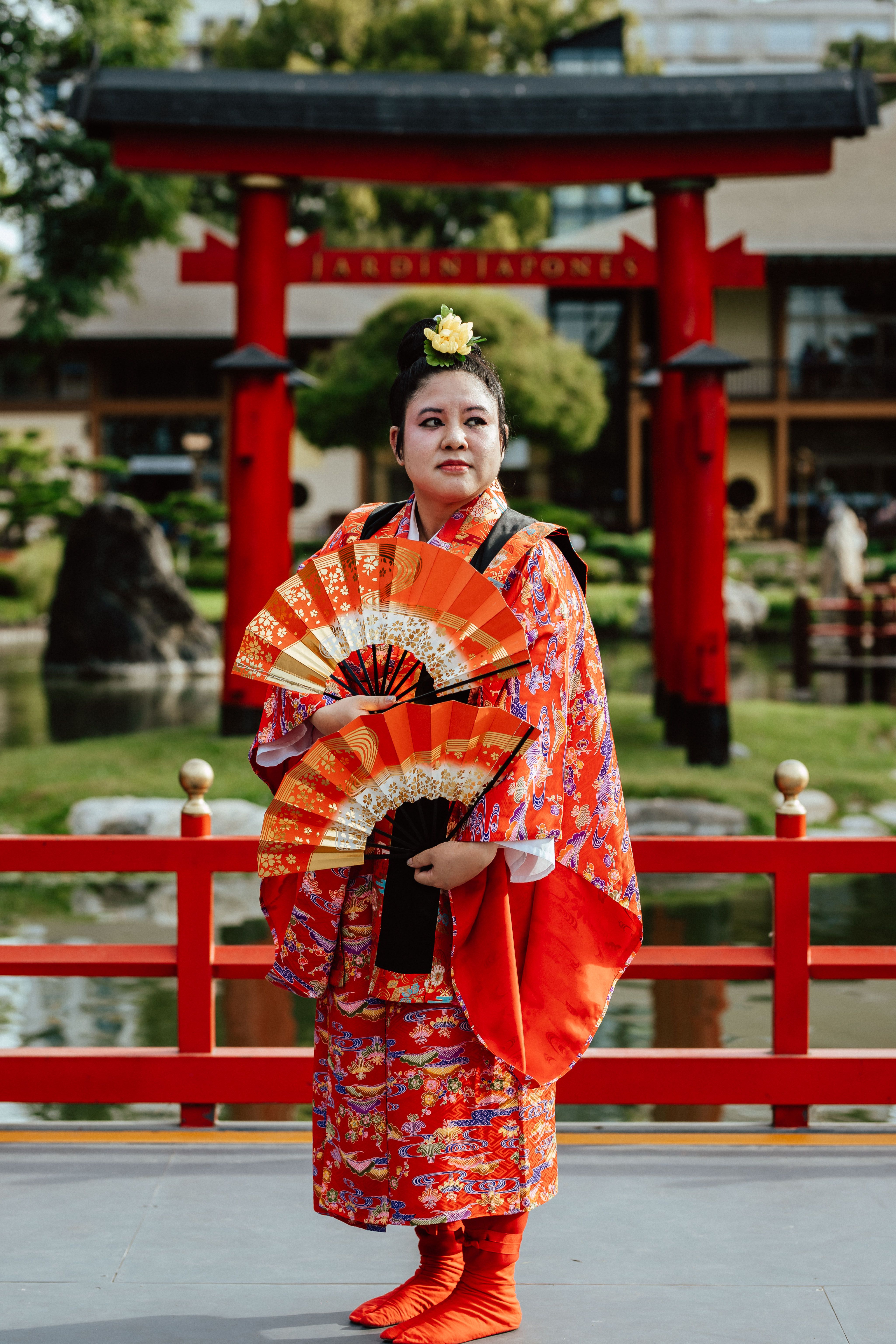 Elegant portrayal of a woman in traditional kimono with a fan at the Buenos Aires Japanese Garden.