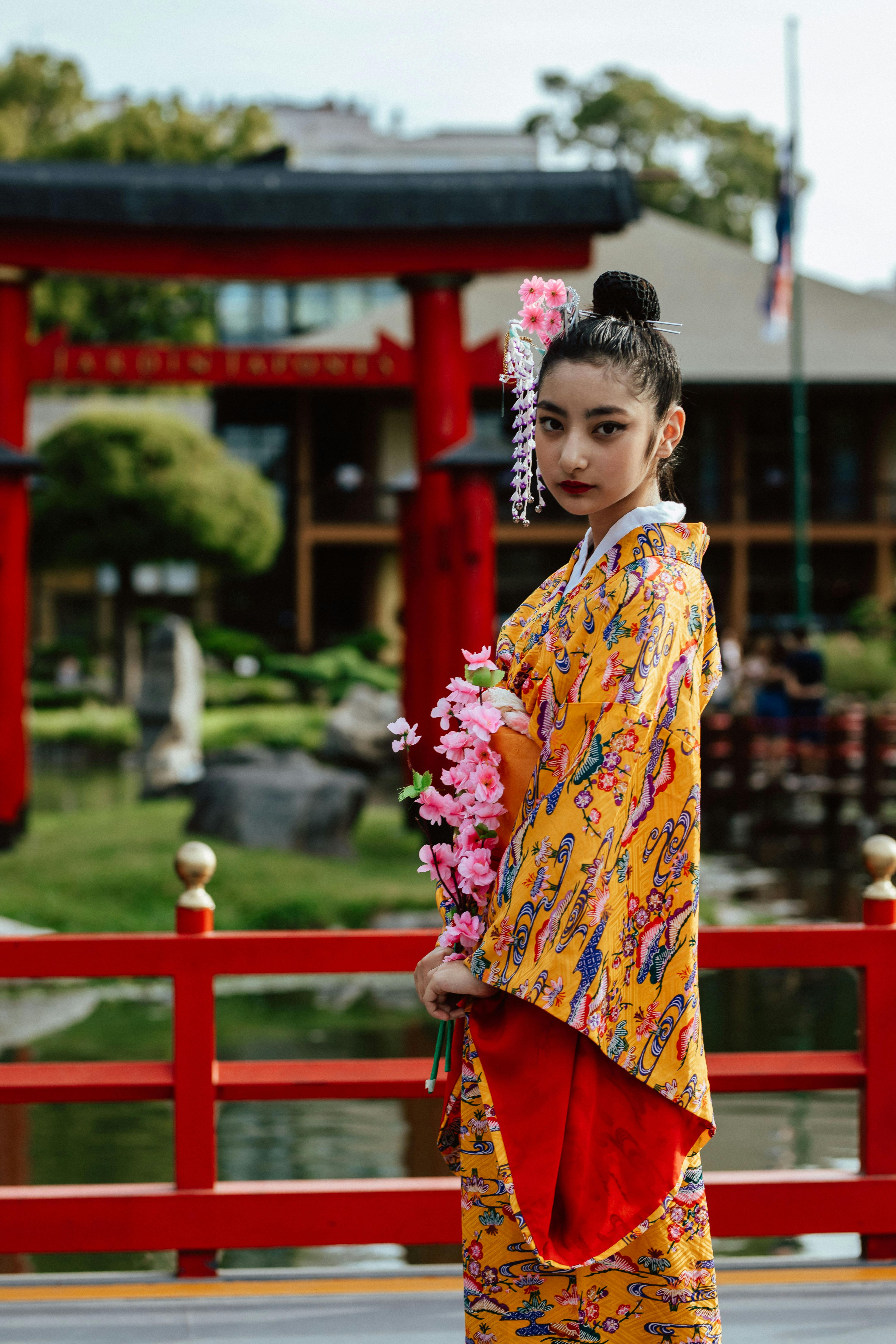 Woman in traditional Japanese kimono standing beside a red Torii gate in Buenos Aires.