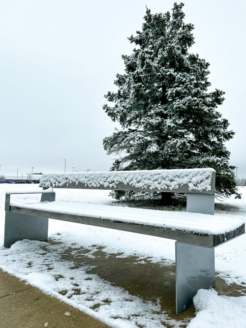 Free A serene outdoor winter scene featuring a snow-covered bench and a snowy tree. Stock Photo