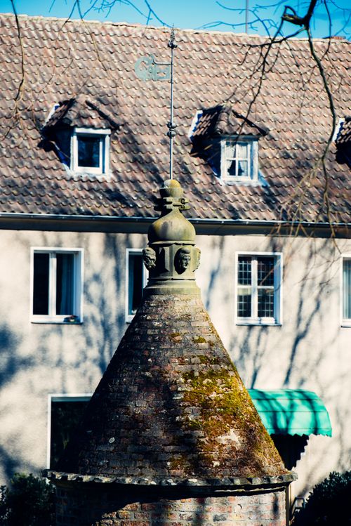 Free Close-up of a moss-covered brick turret with residential building in background, daylight. Stock Photo