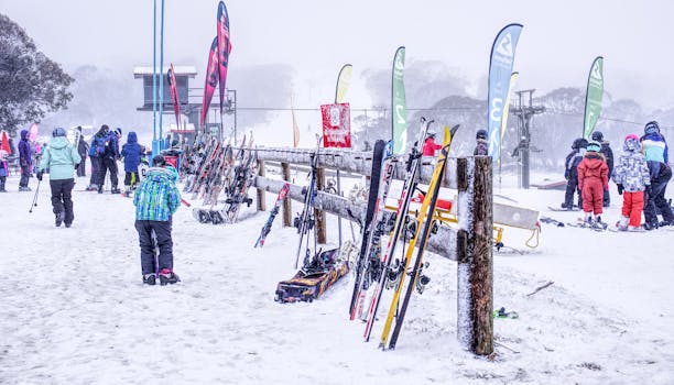 Snowy ski resort scene with people and ski equipment ready for winter activities.