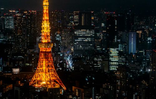 Free A stunning night view of Tokyo Tower glowing amidst the bustling cityscape of Tokyo. Stock Photo