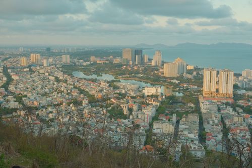 Free Aerial view of a coastal cityscape with ocean backdrop during sunrise. Stock Photo