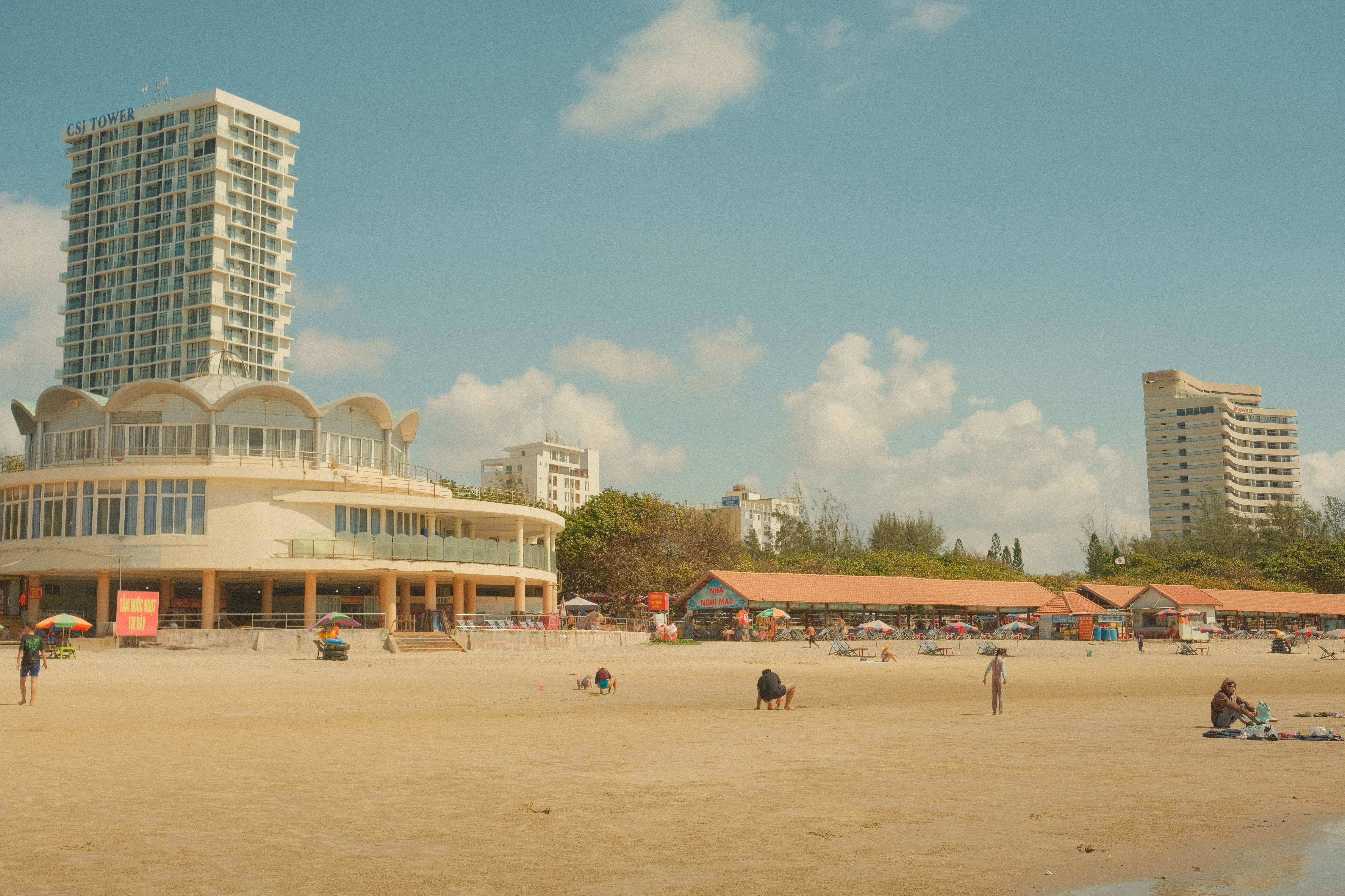 Sunny Beachfront with Modern High-Rise Hotel · Free Stock Photo