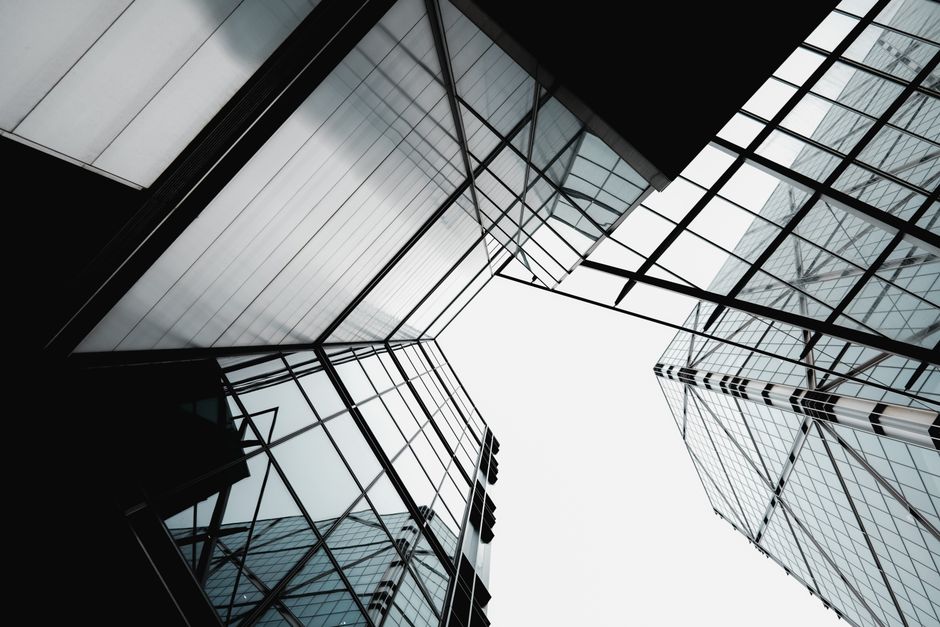 Abstract view of modern glass skyscrapers forming geometric patterns against a clear sky.
