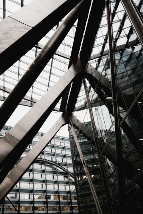 Free Dramatic view of a modern steel and glass building interior showcasing architectural symmetry. Stock Photo