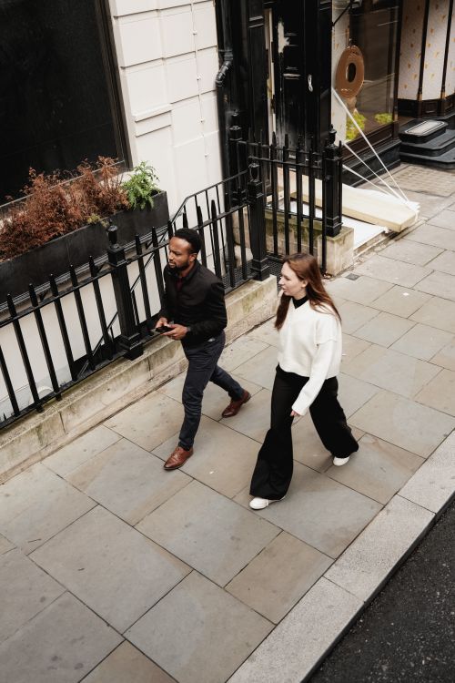 Free A man and woman walking on a city sidewalk, viewed from above. Stock Photo