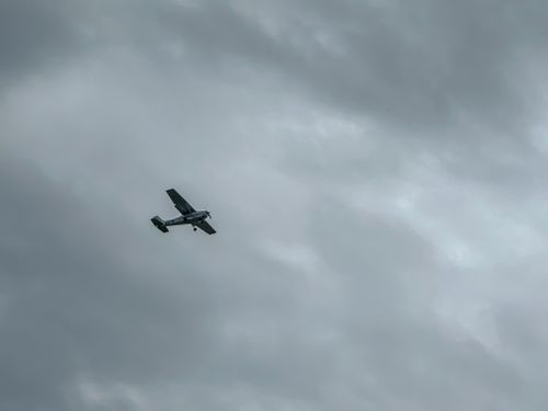 Free A single engine airplane navigates against a backdrop of cloudy skies, capturing the essence of flight. Stock Photo