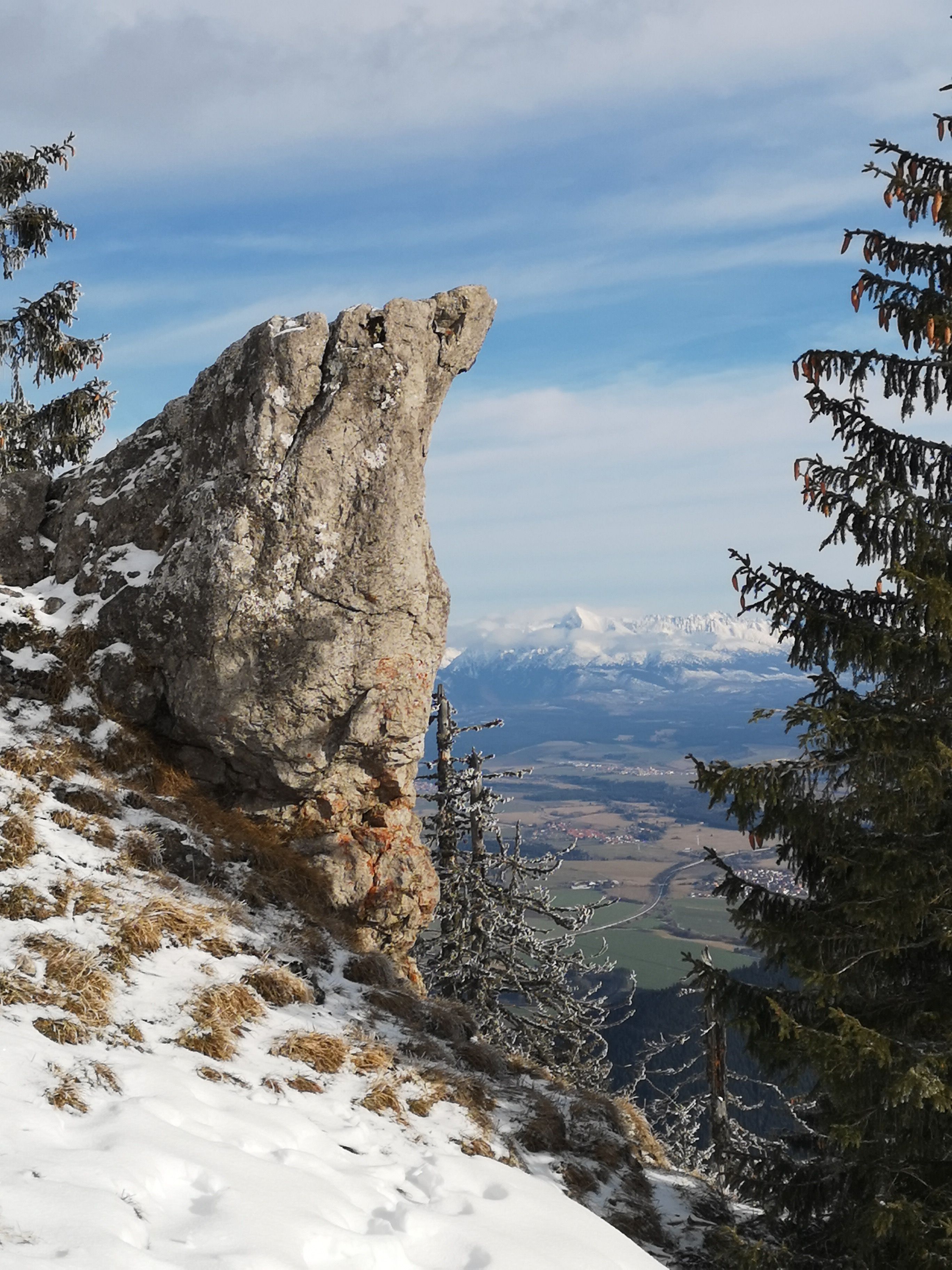 Dramatic Rocky Outcrop Overlooking Snowy Landscape · Free Stock Photo