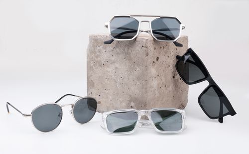 Free A diverse selection of sunglasses displayed on a textured concrete block, perfect for summer fashion. Stock Photo