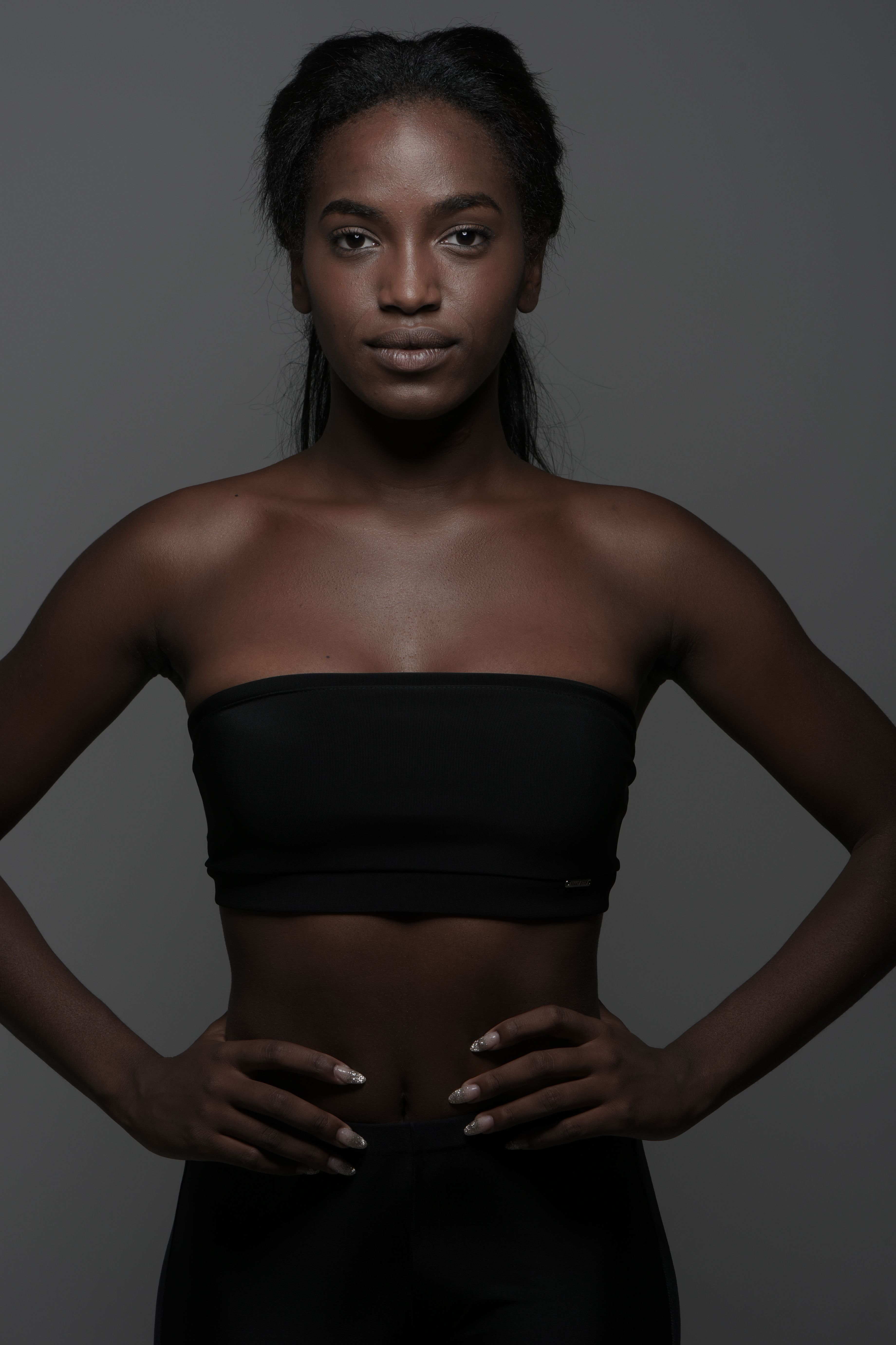 Portrait of a strong woman in athletic wear, showcasing confidence and strength in a studio setting.