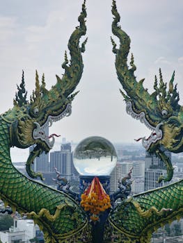 Exquisite dragon sculpture in Chonburi, Thailand with city skyline in background.