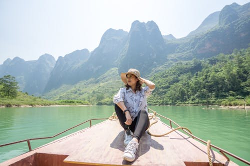 A Woman in White Button-Up Shirt Sitting on a Boat