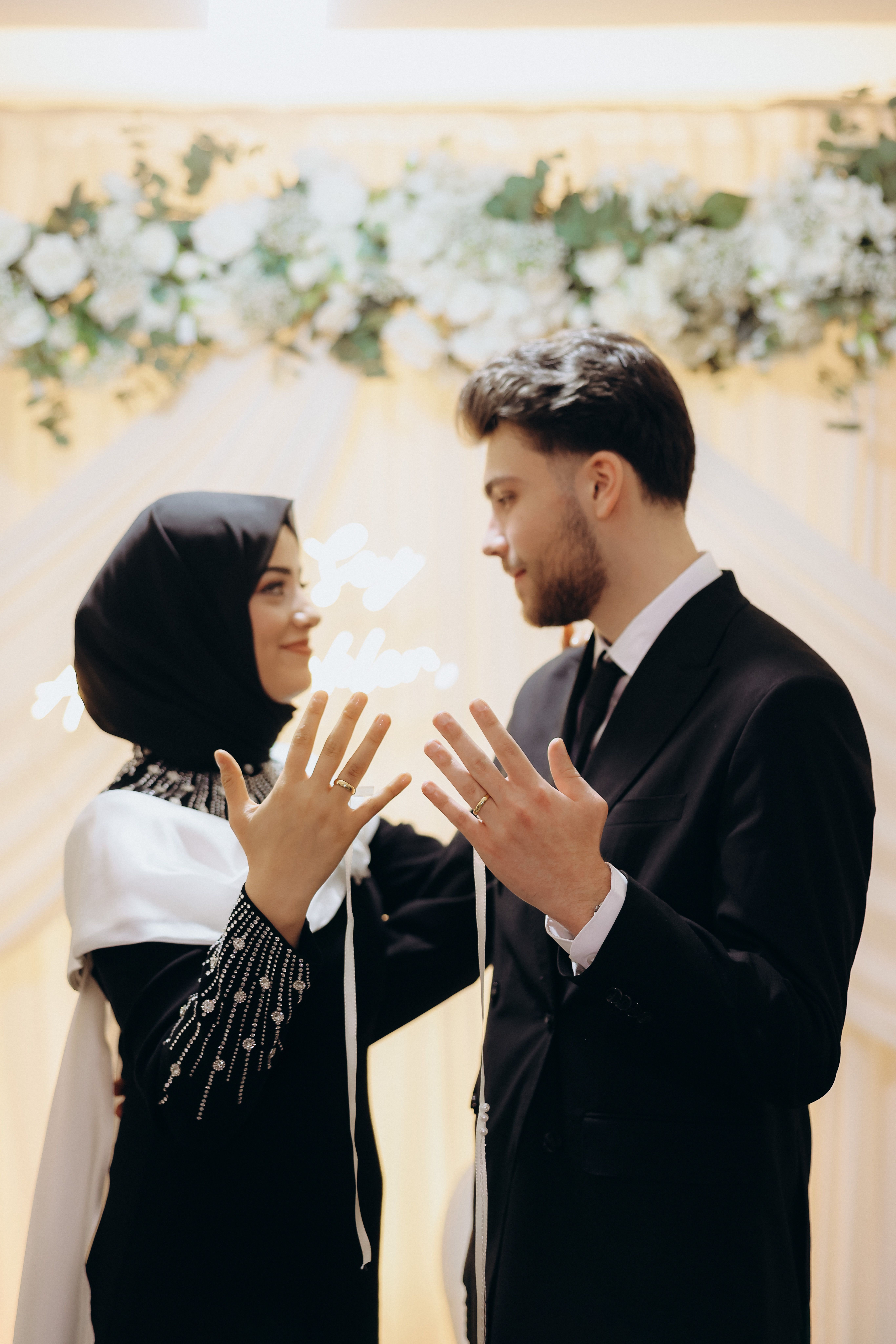 Muslim bride and groom displaying wedding rings after their marriage ceremony