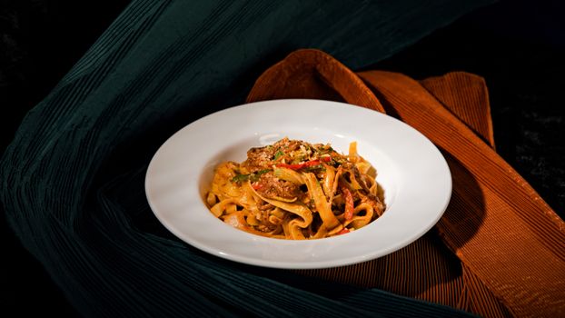 A mouthwatering dish of homemade tagliatelle with vibrant vegetables on a stylish background.