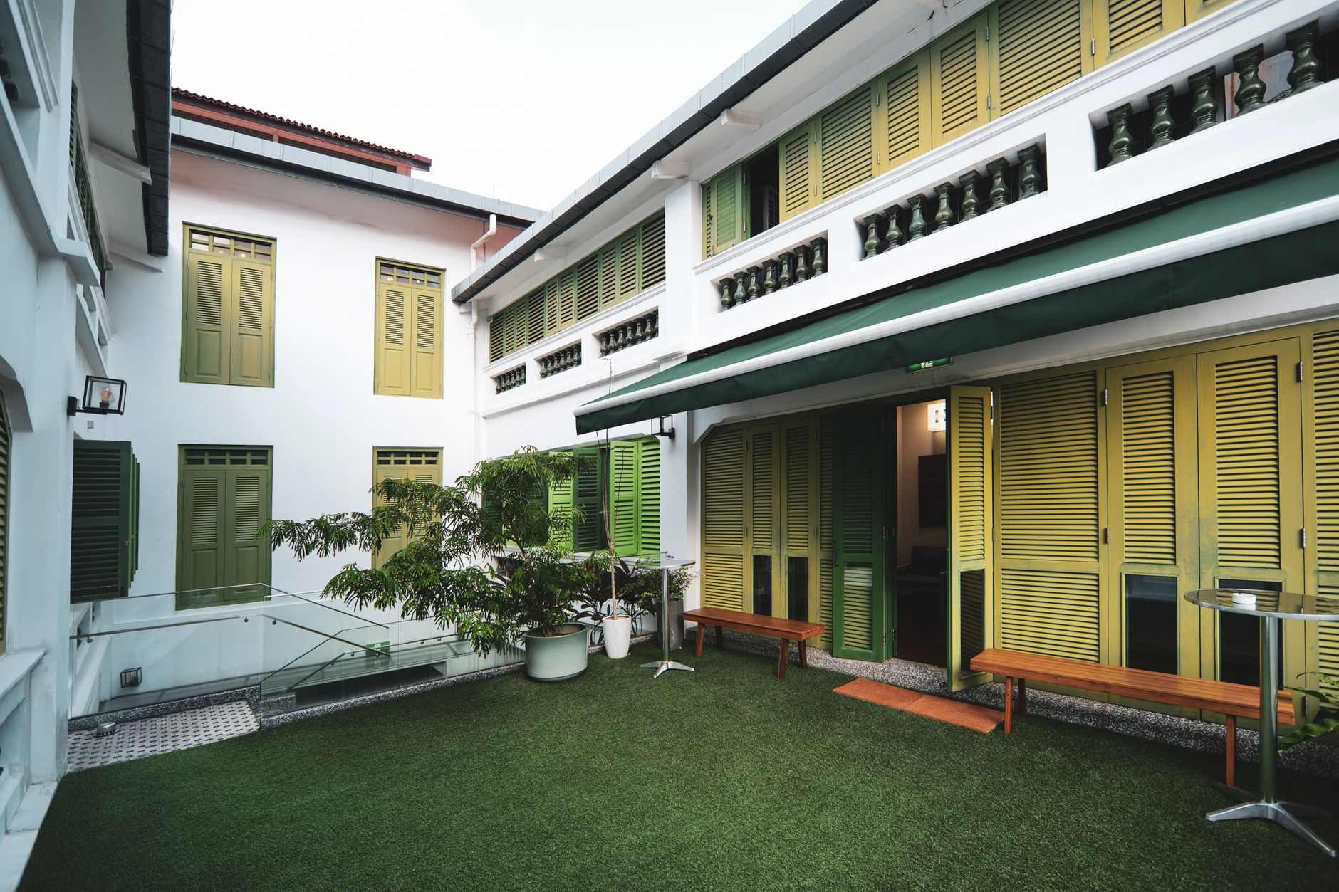 Ivory clapboard B&B with open shutters at golden hour