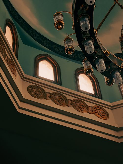 Free Elegant mosque interior showcasing a beautiful ceiling and ornate chandelier, reflecting Islamic architecture. Stock Photo