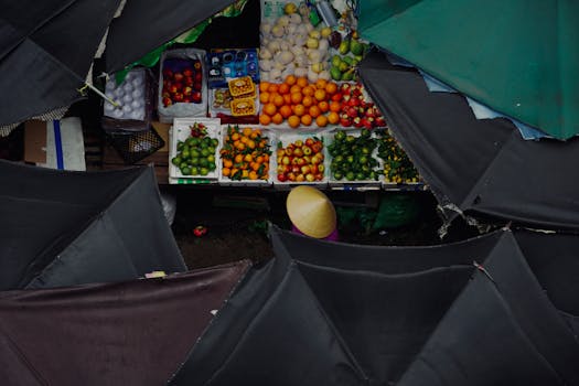 Aerial view of a diverse fruit stand in a bustling market with sheltered covers.