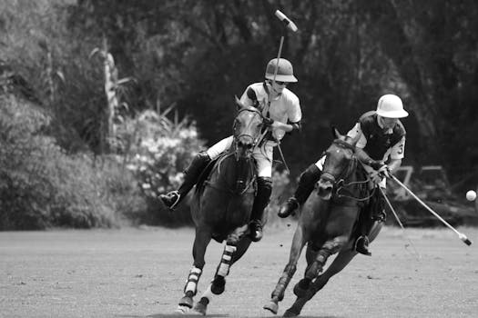 Two polo players in mid-action during a thrilling match captured in black and white.
