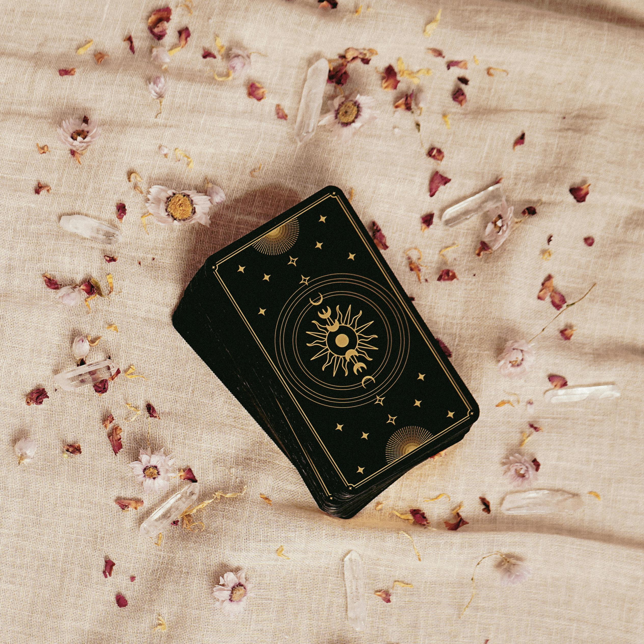 Tarot cards laid out elegantly on fabric surrounded by crystals and petals, evoking mystery.