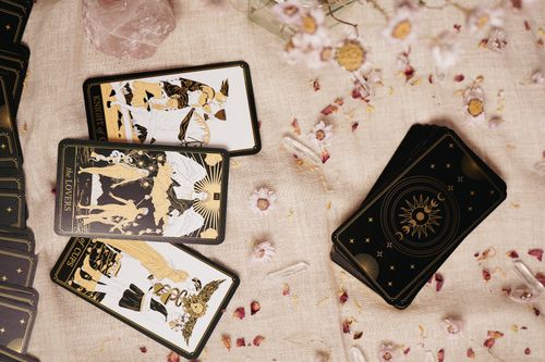 Free Flat lay of tarot cards on a fabric with flowers, crystals, and artistic details. Stock Photo