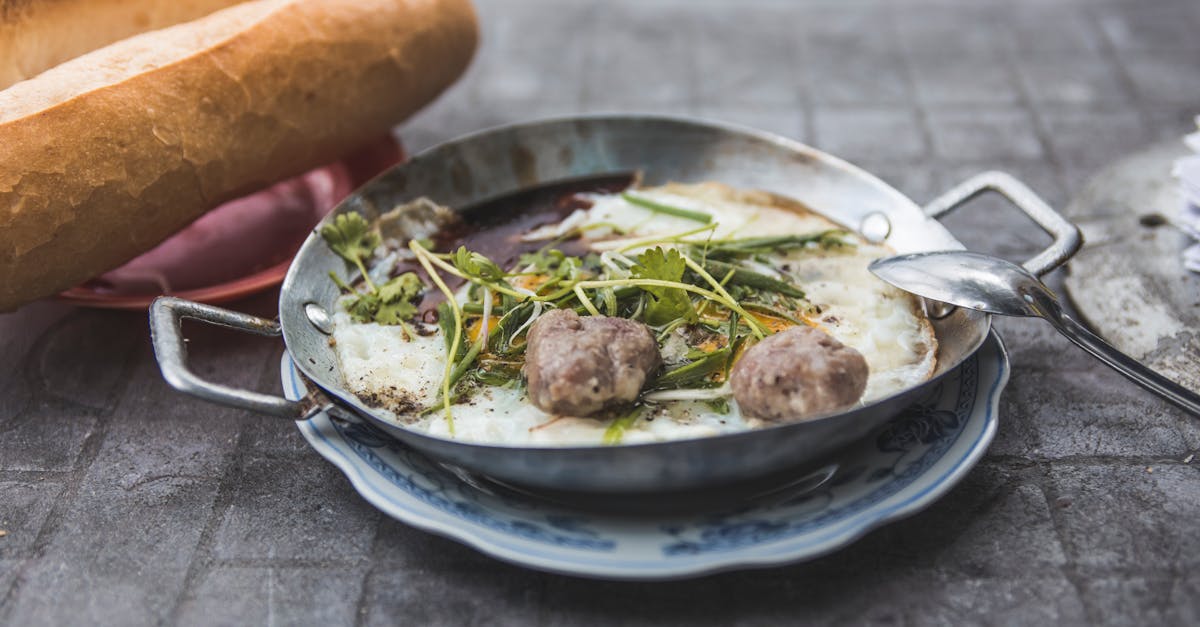 A bowl of steaming meatball sub soup with melted cheese on top