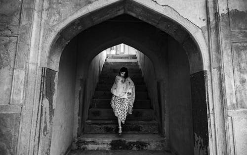 Monochrome Photo Of Woman Walking Down Stairs